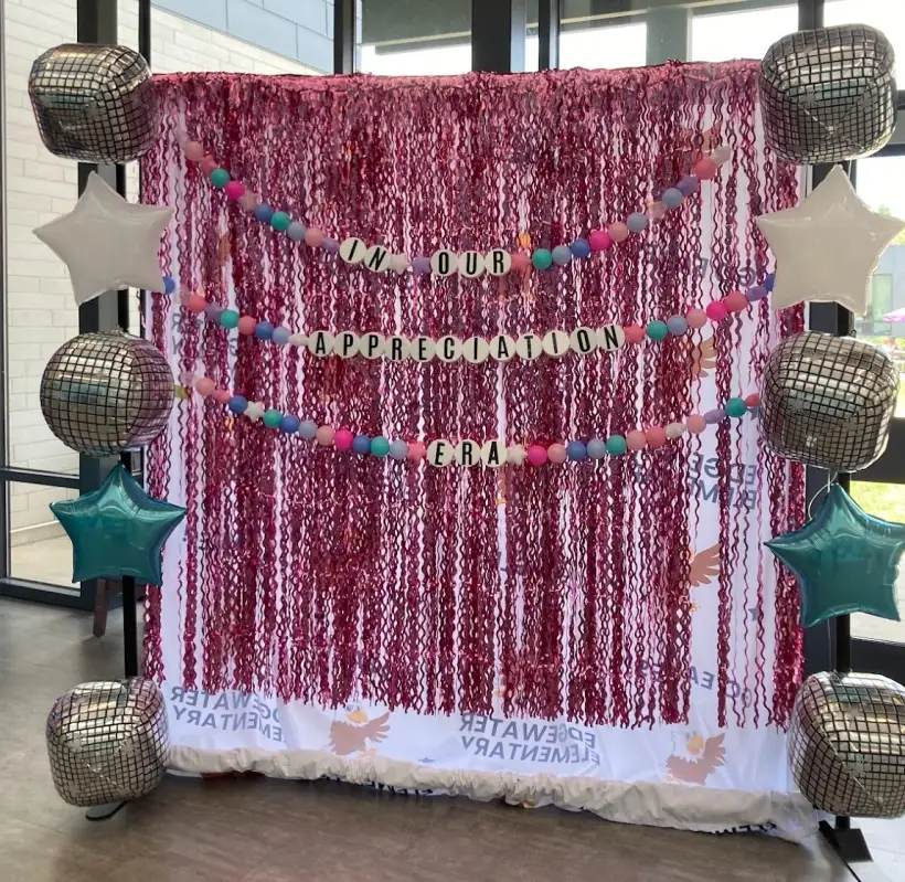 A decorated photo booth backdrop set up for a school dance
