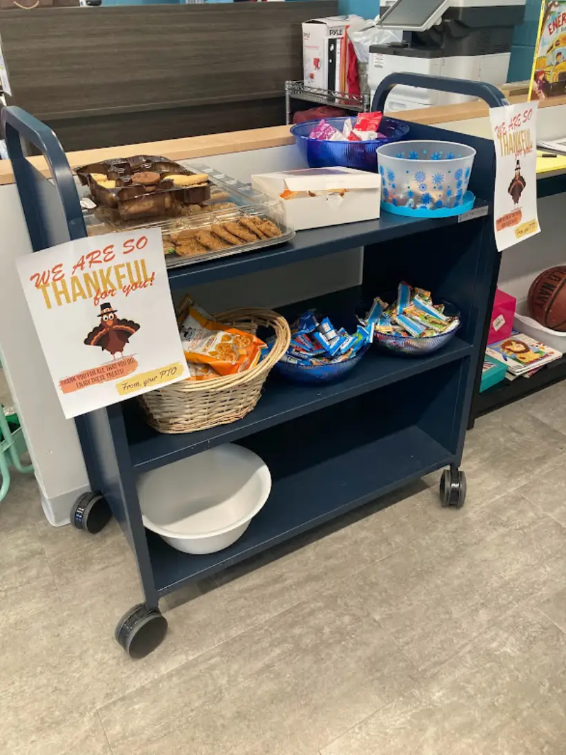 A snack cart in the staff lounge with a hand-made we-are-so-thankful sign